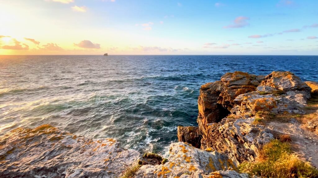 Evening light over the sea from a rocky headland at Trevaunance Cove, St Agnes, Cornwall